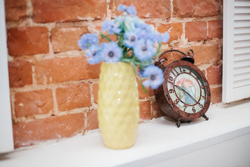clock on wall and blue flowers