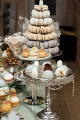Luxury candy bar with pastries, cakes and other sweets, as decoration and entertainment for the holiday guests. Buffet with a variety of delicious sweets, food ideas, celebration.  
