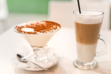 coffee latte with frothy milk in tall glass, rustic style, white background