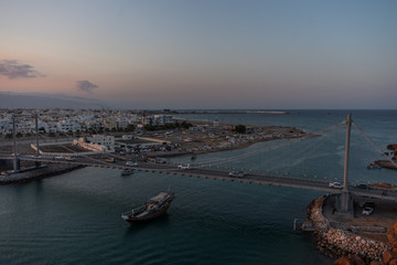 Fototapeta premium Boat crossing the suspension bridge during at Sur's bay, Oman