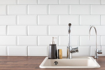 Sink with faucet in the kitchen with copyspace. leanliness, water saving, washing dishes in a bright Scandinavian interior