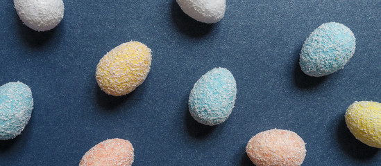 Easter flat lay background of colorful eggs on a blue background, Easter pattern top view with copy space.