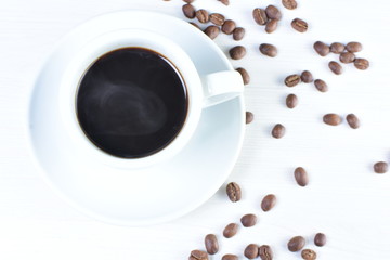 Colombian coffee cup with coffee beans on white wooden background