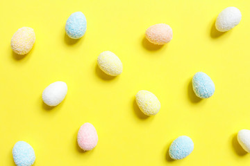 Easter flat lay background of colorful eggs on a yellow background, Easter pattern top view with copy space.
