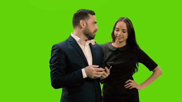 Two business partners using smartphone against green screen background, Chroma key, 4k pre-keyed footage