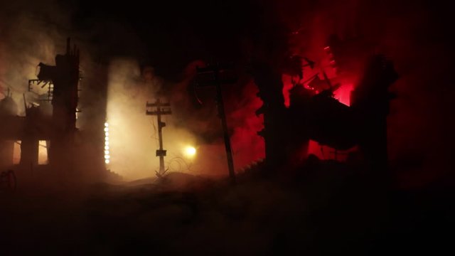 Empty street of burnt up city, flames on the ground and blasts with smoke in the distance. Apocalyptic view of city downtown as disaster film poster concept. Night scene. City destroyed by war.
