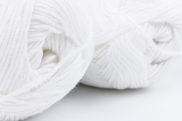 Fototapeta na wymiar woolen white threads on white background. natural wool. knitting. background