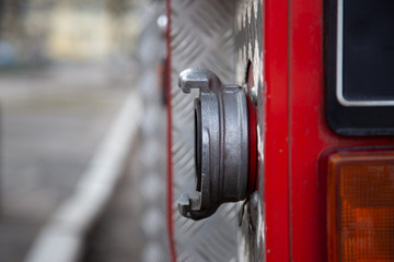 Fire truck with water connection valve in the shallow depth of field. Closeup on the firefightre's equipment wit hcopy space.
