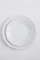 New empty white plates on a clean isolated background. Top view. For any holiday or catering. Catalog. Ceramic plate for food.