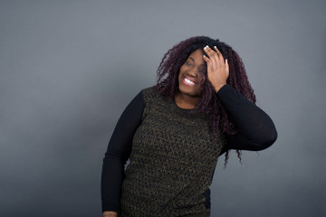 Shot of happy young woman with positive smile, has long hair, rejoices having weekend and good rest after hard working exhausting week, isolated on gray wall.