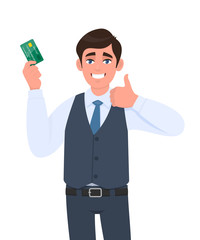 Happy young businessman showing credit, debit card. Man making or gesturing thumbs up sign. Successful person in waistcoat holding ATM card. Stylish male character illustration in vector cartoon.
