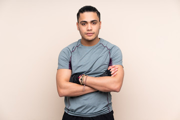 Asian sport man isolated on beige background with arms crossed