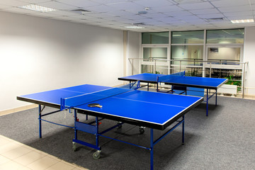 Two blue ping pong tables in the room