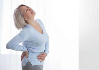 Woman in pain holding her stomach on the right side