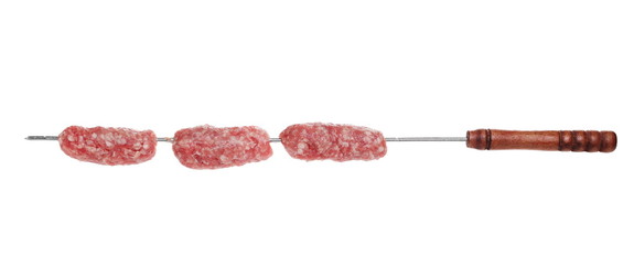 Raw minced pig meat with barbecue fork isolated on white background