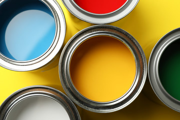 Paint cans on yellow background, top view and closeup