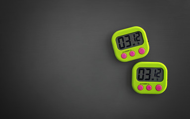 Pair of Digital Stop Watch Running on a Gray Background.