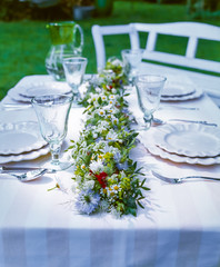 Laid table decorated with flowers outside in the garden