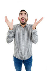 Naklejka premium Portrait of fascinated excited young guy looking up with happy expression and raising arms, standing over white background. Boyfriend sings to gilfriend while standing near her balcony