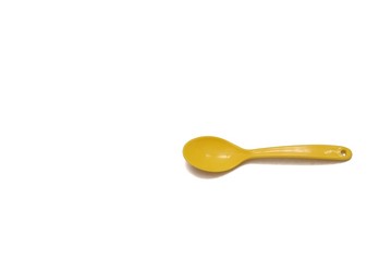 A small yellow kids spoon on white isolated background with copy space