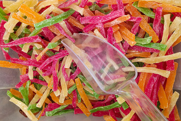 Dried Pineapple Slices. Colored dried tropical fruits. Dried fruits in a container on sale. Sale by weight in the store. Close