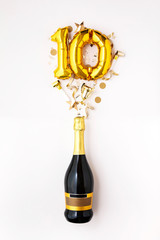 Happy 10th anniversary party. Champagne bottle with gold number balloon.