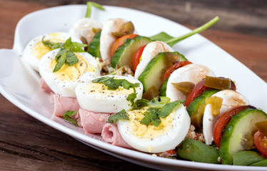 healthy and balanced meal of egg salad with bocconccini and cucumber