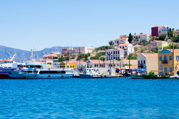 A lot of tiny colorful houses on the rocky shore of Mediterrenean sea on Simy greek island in sunny summer day, tourism on exotic islands tourism on exotic islands © Sunny_Smile