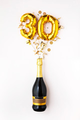 Happy 30th anniversary party. Champagne bottle with gold number balloon.