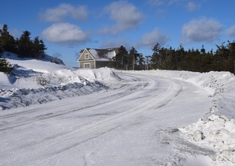 snow covered curved road after snow plow has passed in an rural area