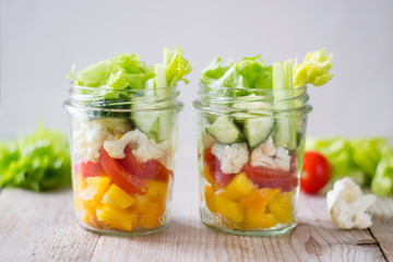 Fototapeta na wymiar Healthy salad jar with celery, cherry tomatoes, cucumber, pepper. Raw vegetarian meal for diet, detox, clean eating. Homemade concept.