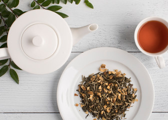 Modern table setting with tea and teapot from above on ship lap white background