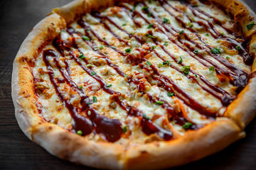 Pizza with chicken and barbeque sauce . Italian pizza on wooden table background