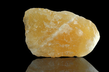 Natural yellow aragonite chips from Mexico. Isolated on a black mirror background.