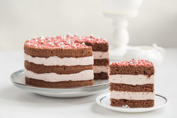 Homemade chocolate cake with cream and raspberries mousse, pink decoration. Homemade.