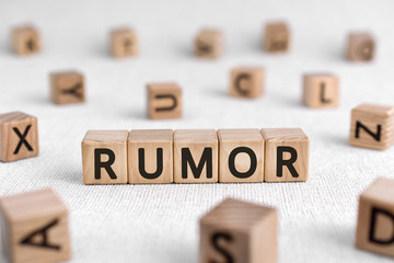Rumor - words from wooden blocks with letters, a currently circulating story rumor concept, white background