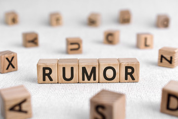 Rumor - words from wooden blocks with letters, a currently circulating story rumor concept, white...