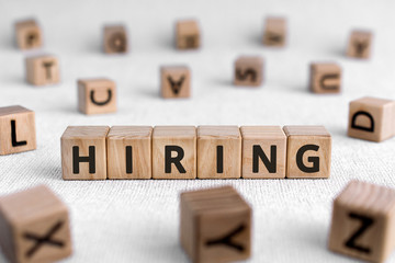 Hiring - words from wooden blocks with letters, employ someone hiring concept, white background