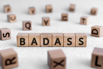 Badass - words from wooden blocks with letters, bad or slightly frightening person badass concept, white background