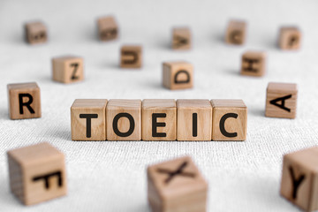 TOEIC - words from wooden blocks with letters, Test of English for International Communication TOEIC exam concept, white background