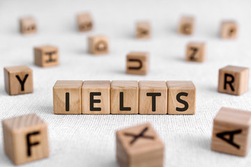 IELTS - words from wooden blocks with letters, International English Language Testing System IELTS exam concept, white background