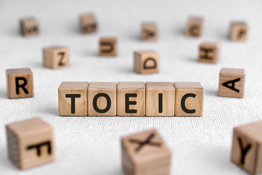 TOEIC - words from wooden blocks with letters, Test of English for International Communication TOEIC exam concept, white background