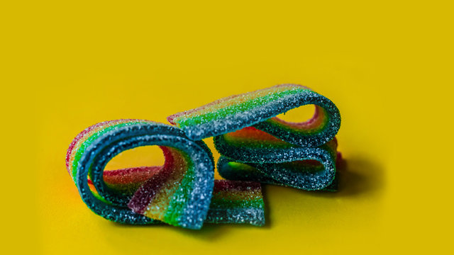Golosina arcoiris. Dulces. Gominolas. Dulce sobre fondo amarilo.