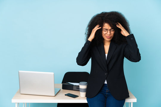 African american business woman working in her workplace with headache