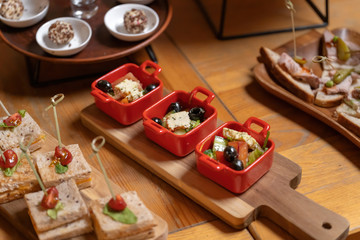Fototapeta na wymiar Organic caesar salad in red bowl with caesar dressing. On a vintage wooden board, luxury catering.