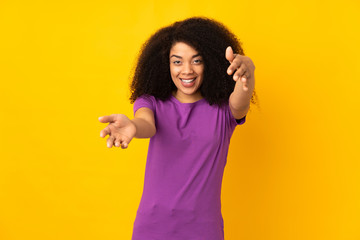 Young african american woman over isolated background presenting and inviting to come with hand