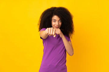 Young african american woman over isolated background with fighting gesture