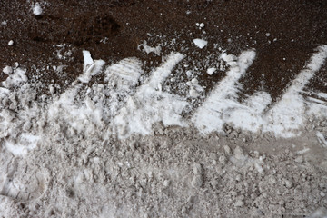 The texture of snow and frozen sand. Snow on the footpath