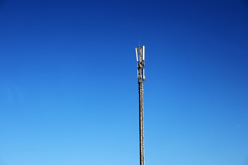 Mobile communications tower on a background of blue sky. Technological pillar and sky. Antenna