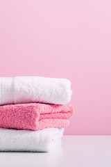 Fototapeta na wymiar Stack of soft towels on pink background, bathroom